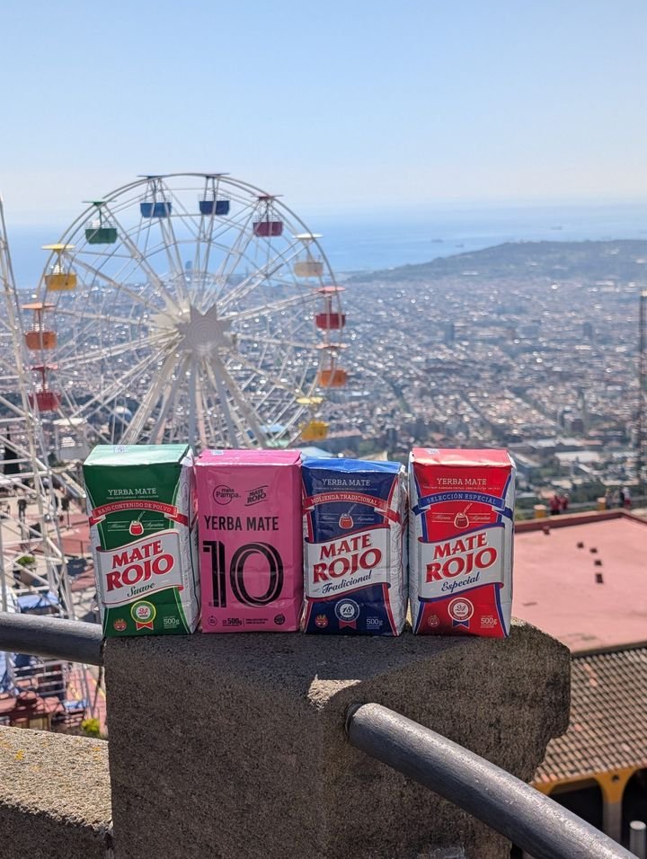 Paquetes de Yerba Mate Rojo con la noria del Tibidabo y Barcelona de fondo